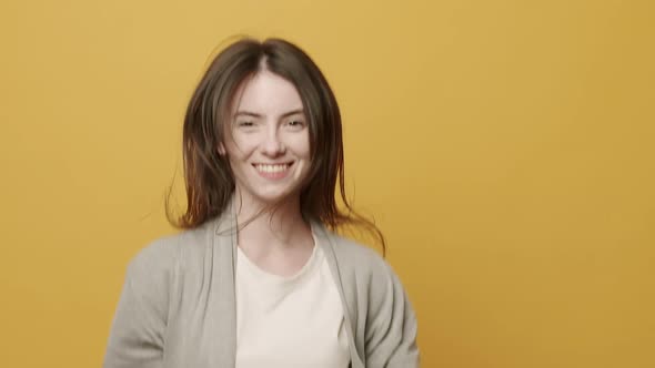 Woman Smiling Dancing to Music Rhythmically to Beat Moving on Yellow Background