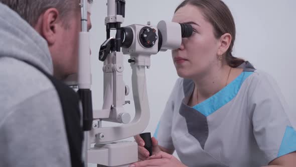 Optometrist Examining the Eyes of a Male Patient in a Modern Ophthalmology Clinic