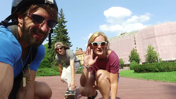 Close up of friends skateboarding in crouched position