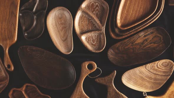 Rich Variety of Wooden Empty Cutting Boards and Plates on Dark Background.