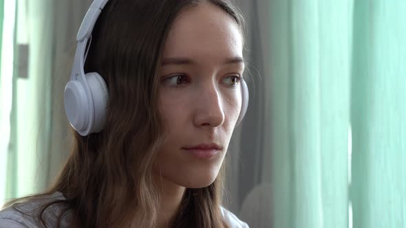 Girl Student Wearing Headphones Studying Online with Internet Teacher Looking at Laptop