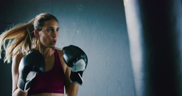 Athletic Woman Training Kickboxing in the Gym