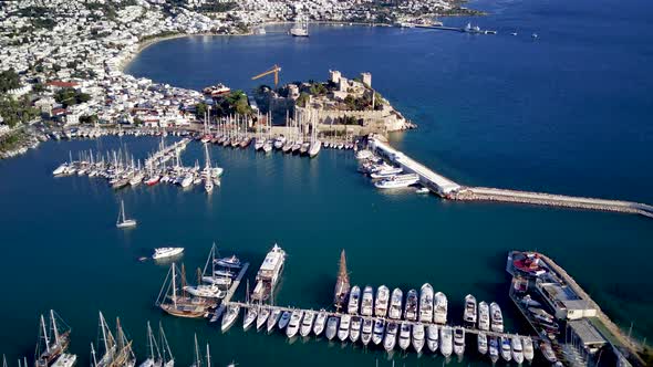 View from drone on full of yachts Bodrum harbour and ancient Kalesi castle in Mugla in Turkey