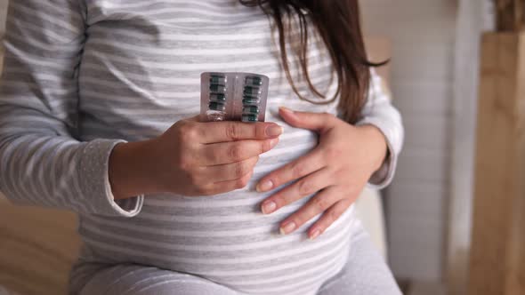 Closeup of a Pregnant Woman Holding a Blister with Pills