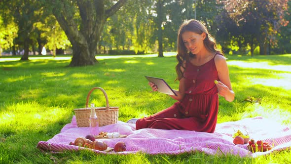Happy Woman with Tablet Computer on Picnic at Park