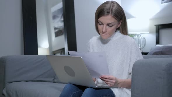 Young Woman Reading Letter Working on Laptop