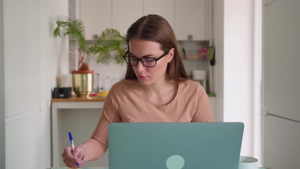 Young Female Millennial Working on Laptop at Home Office