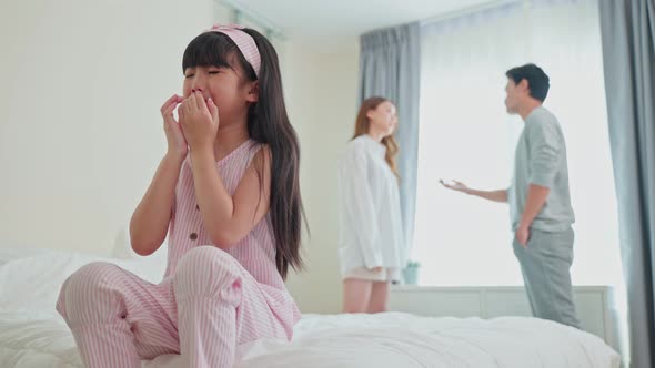 Asian little girl daughter crying while parents fighting or quarrel conflict. Family problem concept