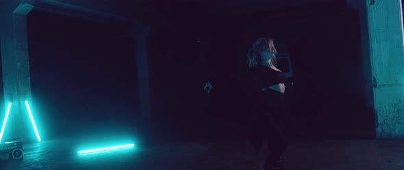 Female Dancer in a dark Parking Lot with Neon Lights