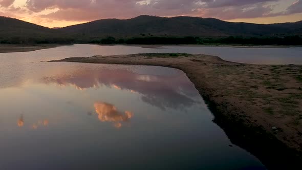 Drone shot flying over a dry lake at dusk