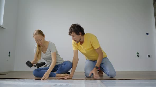 A Family of Woman and Man Install Laminate on the Floor in Their Apartment