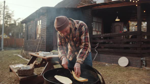 Man Cooking Tortillas on BBQ Grill