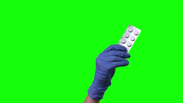 Doctor Shows Pills, Female Hands in Protective Blue Gloves Closeup at Green Screen