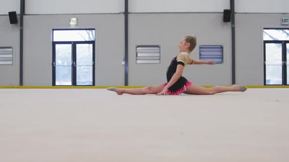 Teenage female gymnast performing at sports hall