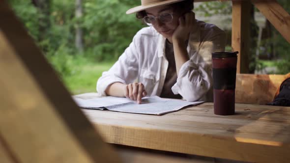 Girl Bright Traveler Tourist Sits Looking At A Map, Girl In A Hat With A Backpack Resting Sits