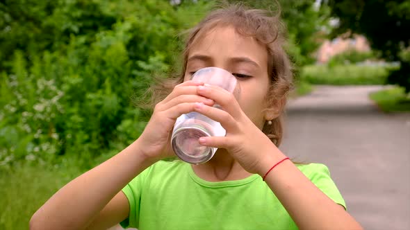 The Child Drinks Water From a Glass