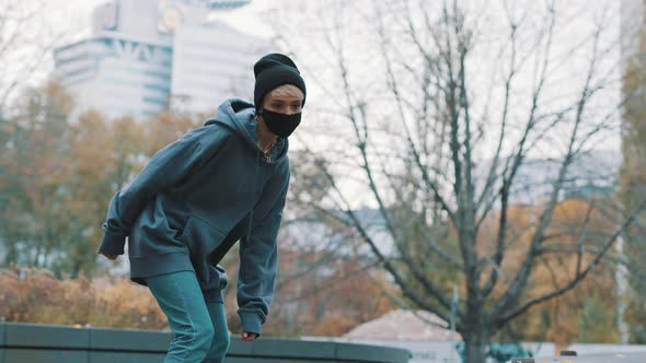 Young Blonde Woman with Face Mask Skating in the Skatepark in Autumn