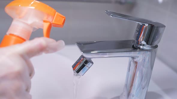 Close-up of a Spray of Cleaning Agent on a Chrome Faucet in the Bathroom. Hygiene, House Cleaning