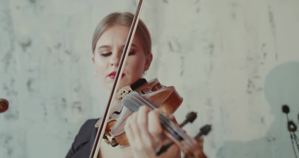 Admiring Female Musician Playing the Violin Emotionally at Camera