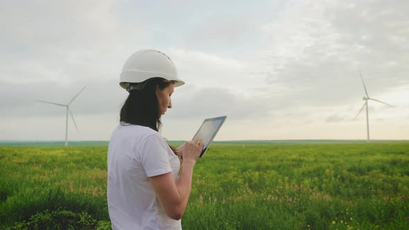 Woman Engineer Working in Wind Turbine Electricity Industrial at Sunset