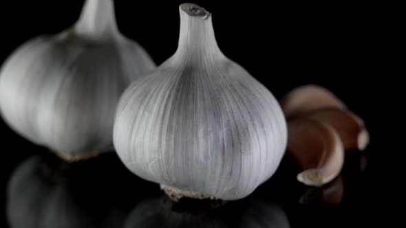Closeup of Organic Two Heads of Garlic That Lie on a Table Isolated on a Dark Background