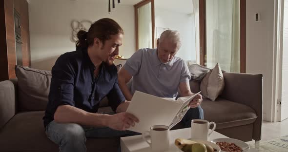 Father and Son Examining Photos Together