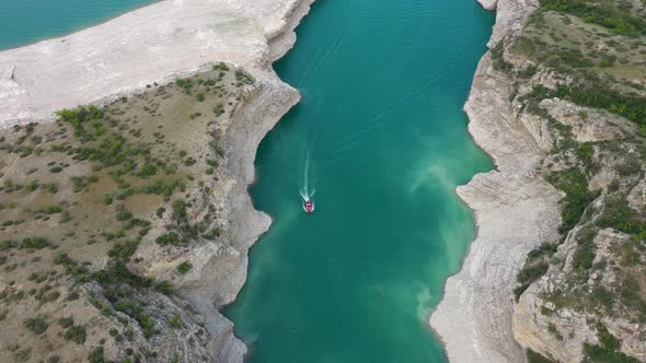 Top view of a mountain river in the canyon and  boat sailing along a turquoise river among the rocks