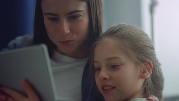 Girl Mother Holding Tablet Computer Play Online Games Together in Room Closeup