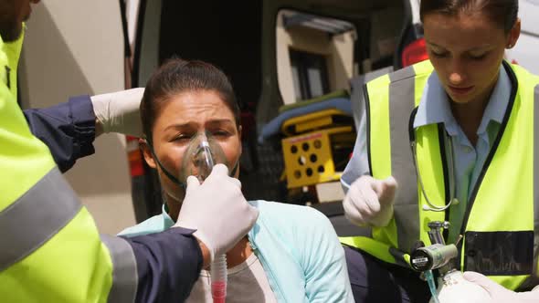 Patient receiving oxygen mask from ambulance team