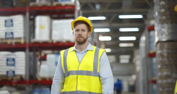 Portrait Caucasian Warehouse Male Worker Standing with Arms Crossed and Smiling in Warehouse