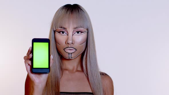 Woman with futuristic make up showing smartphone display