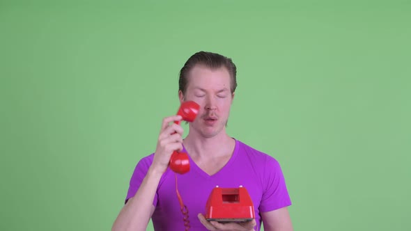 Face of Stressed Young Man Using Old Telephone