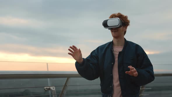 Man in Virtual Reality Glasses Playing Games Outdoors