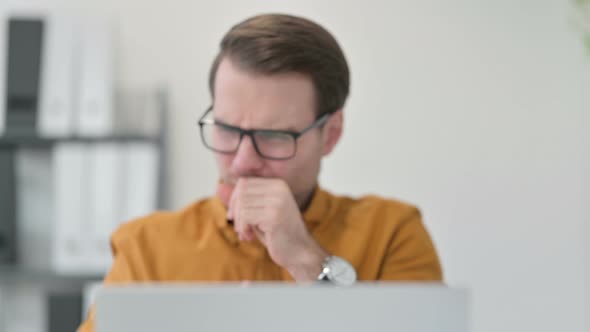 Close Up of Young Man with Laptop Coughing in Office 