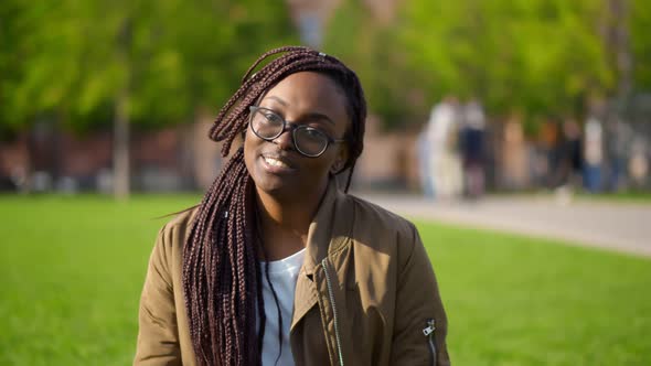 Young Afro Woman Having Video Call Greeting Friend Sitting Green Grass in Park