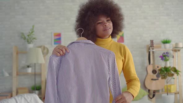 Portrait African Woman with an Afro Hairstyle Trying on Clothes in Front of a Mirror