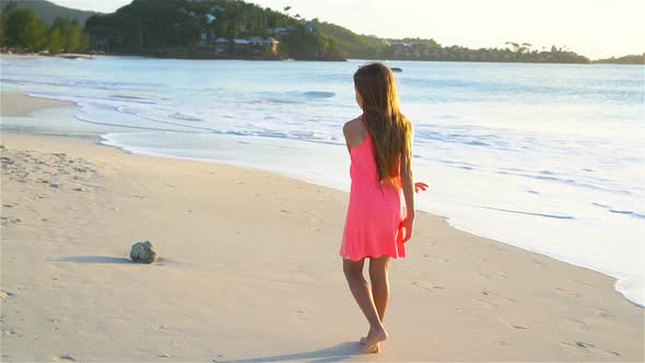 Adorable Happy Little Girl Having Fun on White Beach at Sunset, SLOW MOTION