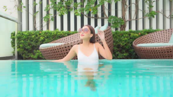 Young asian woman enjoy around outdoor swimming pool for leisure