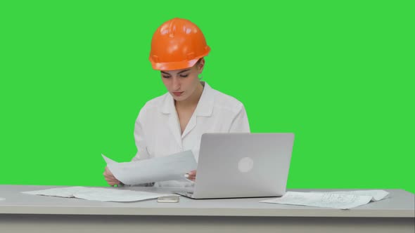 Young Engineer Woman Reading Technical Drawings on a Green Screen, Chroma Key