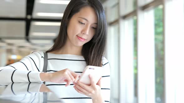 Woman use of cellphone in train station