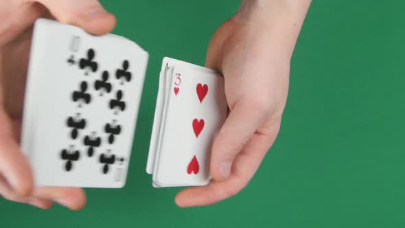 Playing Cards Being Shuffle on a Green Surface By Magician