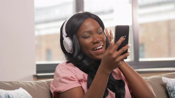 Woman with Smartphone Listening To Music at Home