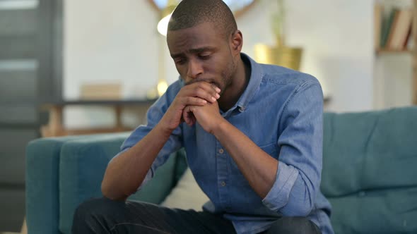 Worried Young African Man Having Headache on Sofa 