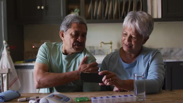 Senior mixed race couple having online medical consultation using smartphone