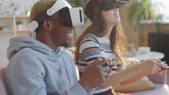Cheerful Couple Playing Video Game on VR Headsets