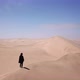 A Young Woman Walks Along Sandy Dunes on Seashore - VideoHive Item for Sale