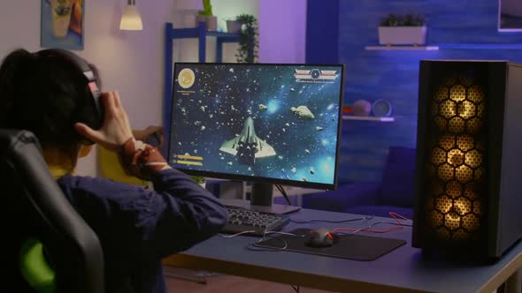 Gamer Playing Space Shooter Video Game on Powerful Computer