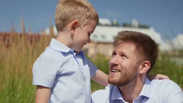 Happy Caucasian Father and Son Portrait Playing Together Outdoors