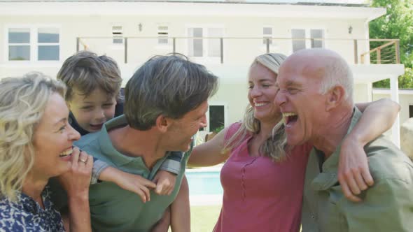 Portrait of happy caucasian family looking at camera in garden