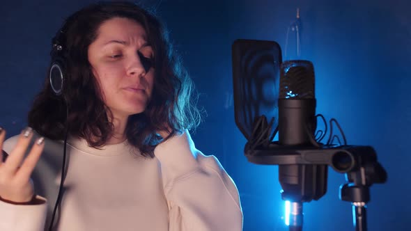 a Young Songwriter Stands in a Recording Studio in Front of a Professional Microphone